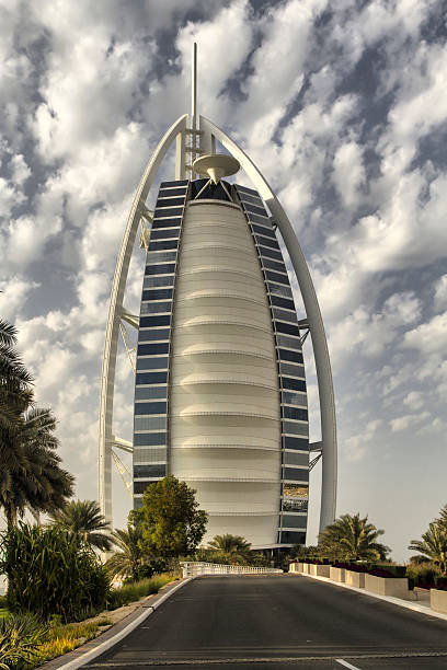 Dubai - Burj Al Arab Dubai, United Arab Emirates - January 9, 2013: a spectacular view of the famous Hotel Burj Al Arab during a cloud day. The most luxury hotel in the world jumeirah stock pictures, royalty-free photos & images