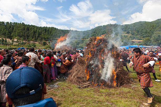 Village Menschen springen über zwei Brennen haystacks im Thangbi festival – Foto