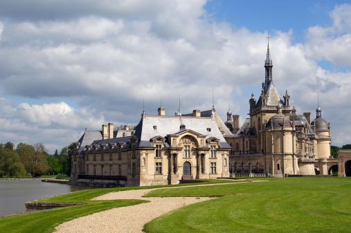 Chantilly, France- May 12, 2012: Chateau de Chantilly ( Chantilly Castle ), located in the town of Chantilly, France. The Chateau consists of two buildings: Petit Chateau (built in 1560) and Grand Chateau (was destroyed during the French Revolution and rebuilt in 1870). The Chateau is Musee Conde - one of the best art galleries in France