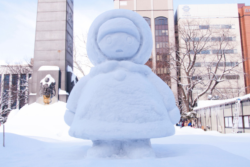 Sapporo, Japan - Feb. 7 2013 : Snow sculpture of a little girl wearing down with hat at Sapporo Snow Festival 2013 in Sapporo, Hokkaido, japan. The Festival is held at Sapporo Odori Park. The festival is one of Japan's largest winter events, attracts a growing number of visitors from Japan and abroad every year.