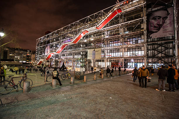 Centre George Pompidou by night, Paris Paris, France - December 26, 2012: Centre George Pompidou by night, Paris. Shot made during Christmas Holidays, big exhibition of Salvador Dali, poster visible on the wall. Numerous tourists visiting famous museum every day. pompidou center stock pictures, royalty-free photos & images