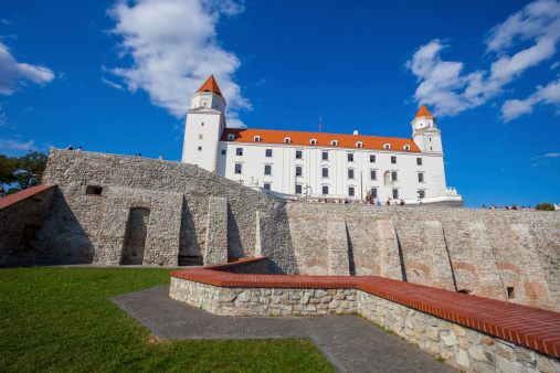 Bratislava, Slovakia - September 12, 2011: View of Bratislava castle which occupies a prominent location in the city overlooking the Danube river. People can be seen on the edge of a wall looking out and enjoying the view.