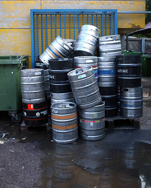 Used beer barrels LONDON, ENGLAND - JULY 28, 2013 : People are drinking less - but deaths from excessive drinking are rising steadily, according to the latest government statistics, published by the NHS Information Centre. pileup stock pictures, royalty-free photos & images