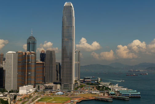 Hong Kong, China - July 30 2013: Central Area of Hong Kong Island and Victoria Harbour with skyscrapers, harbor with piers, boats and sea - viewed from Wan Chai