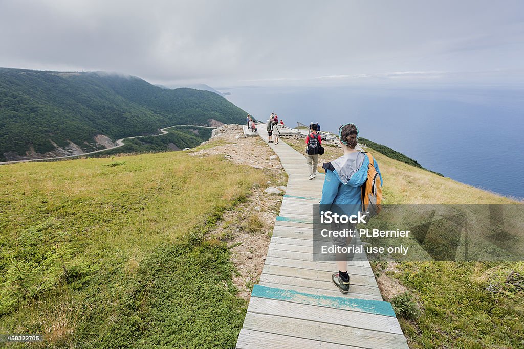 Hikers on the Skyline trail. Cape Breton Highlands National Park, Nova Scotia, Canada - July 19, 2012: Tourists and hikers enjoying the view of the Skyline trail, one of the most popular hike of the Cape Breton Highlands National park in Nova Scotia. The hiking trails are located around the Cabot Trail that circles the Cape Breton peninsula. Cape Breton Island Stock Photo