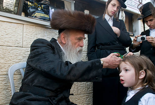 Halake Meron , Israel - May 10, 2012 : Rabbi cuts child's hair in a Halake ceremony in Bar Yochai tomb , Halake is a first haircut ceremony celebrated in Lag Ba'omer hasidism photos stock pictures, royalty-free photos & images