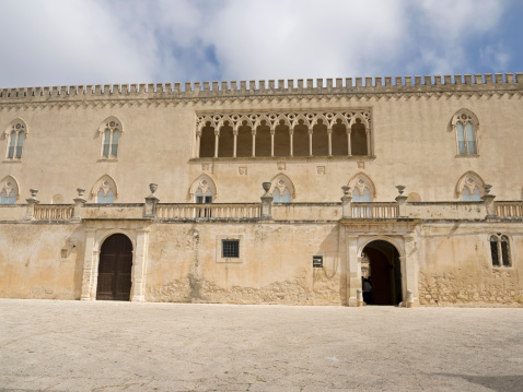 Santa Croce Camerina, Sicily, Italy - June 2, 2013: The Donnafugata Castle, situated in proximity to Santa Croce Camerina, about 20km from Ragusa is a major attraction for tourists. Thanks to its scenery, it was the setting of many films. The name of Donnafugata, which is Arabic in origin, is misleading. It does not, in fact, refer, as first appearances might suggest, to a woman fleeing some tyrannical husband or father, nor to one of the legends lingering in some popular memory, but is a free interpretation and transcription of Ayn as Jafat (meaning Fountain of Health) which in Sicilian dialect became Ronnafuata and so was corrupted to its modem form of Donnafugata.