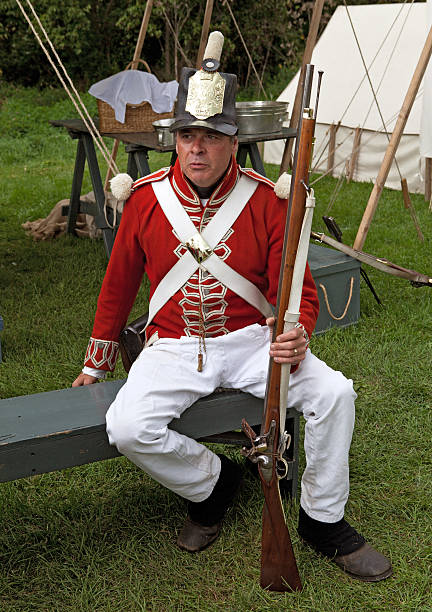 Soldier with a rifle Streetsville, Ontario, Canada - September 15, 2012: War of 1812 reenactment in Streetsville Memorial Park.  British soldier resting before the battle. trishz stock pictures, royalty-free photos & images