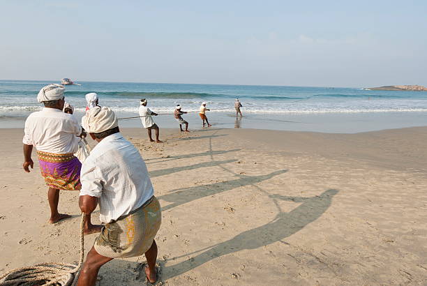 indian rybaków, wyciągnij ich seine się do kovalam, indie. - commercial fishing net fishing net fishing fishing industry zdjęcia i obrazy z banku zdjęć