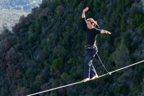 Tavertet, Spain - April 13, 2013: Man practicing highline in Tavertet, Spain on April 13, 2013. Highline is a balance sport that consists walking through a rope clamped between two points and great height below.