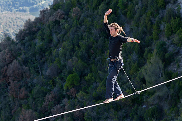 Highlining Tavertet, Spain - April 13, 2013: Man practicing highline in Tavertet, Spain on April 13, 2013. Highline is a balance sport that consists walking through a rope clamped between two points and great height below. highlining stock pictures, royalty-free photos & images