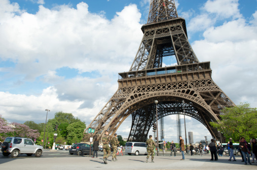 Paris, France - May 13, 2013: Armed soldiers go on patrol at the Eiffel Tower. One of the top tourist destinations in the world, the tower also attracts political protests, bomb scares, terrorist threats, and suicide attempts.