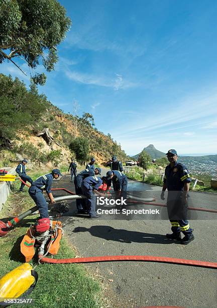 Photo libre de droit de Équipe De Pompiers Fonctionner Pompe À Eau Sur Les Pistes De La Montagne De La Table banque d'images et plus d'images libres de droit de Accident et désastre