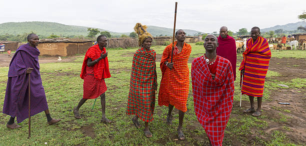 Masai Mara, Kenya - February 2, 2013 - An unidentified African masai men are posing for the money when they are dancing at masai village, very close the masai mara national reserve at oloolaimutia gate on February 2, 2013 in Masai Mara, Kenya. The Masai people are a Nilotic ethnic group of semi-nomadic people located in Kenya and Tanzania.