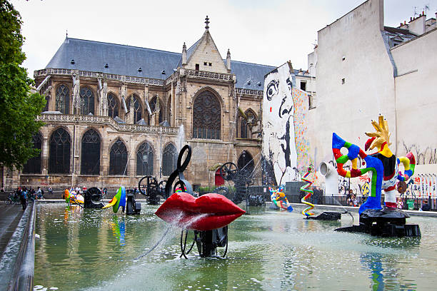Stravinsky Fountain, Paris. Paris, France - June 26, 2012: Stravinsky Fountain  on an overcast summer day. It is ornamented with sixteen works of sculpture, moving and spraying water, representing the works of composer Igor Stravinsky. It is located next to Centre Georges Pompidou. Tourists are walking around and relaxing. pompidou center stock pictures, royalty-free photos & images