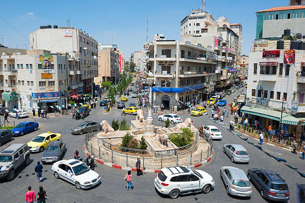 Manara in central Ramallah, West Bank, Palestine Ramallah, West Bank, Palestinian Territories - July 23, 2013: Traffic, pedestrians, and businesses at the Manara, the central traffic circle in downtown Ramallah. Located several miles north of Jerusalem, Ramallah is the seat of the Palestinian Authority government. west bank photos stock pictures, royalty-free photos & images
