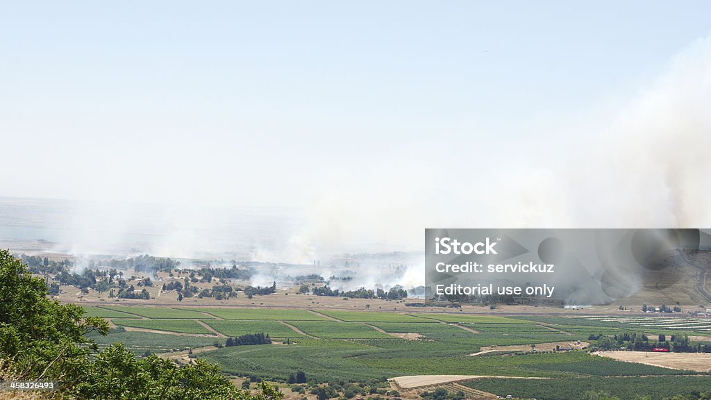 Fuoco e fumo-guerra in Siria vicino al confine israeliano - Foto stock royalty-free di Alture del Golan