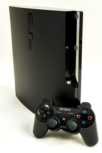 Neeroeteren, Belgium - February 10, 2013: The Playstation 3 from Sony was released in 2006. This is the slim version of the Playstation 3, with a Dualshock 3 controller in front of it