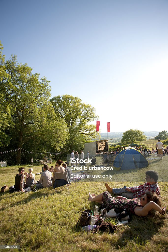 Audience at a live music event Musbury, UK - June 8, 2013: Audience sitting on the ground listening to live music at the Castlewood Wine Festival, Musbury, Devon Music Stock Photo