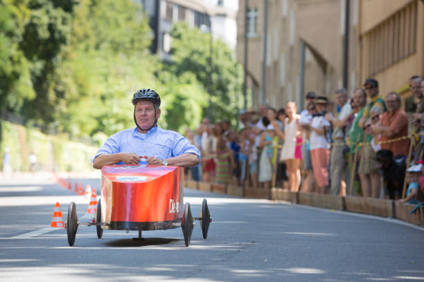 Soapbox car race in Munich Munich, Germany - July 28, 2013: Each year there is a soapbox car race down the Gebsattelberg (small hill within Munich). Locals are competing for the funniest and fastest vehicles. The guy on this image is the politician Diter Reiter running for the next election of the Mayor of Munich. People cheering at the barrier to the track. german social democratic party photos stock pictures, royalty-free photos & images