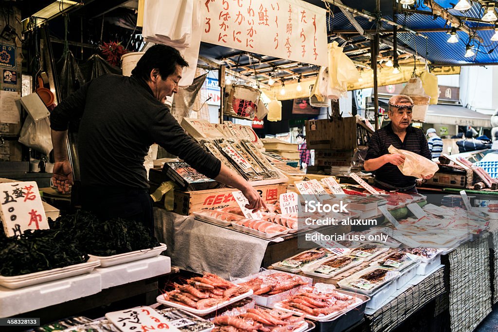 Ameyoko street market Tokyo Japan Tokyo, Japan - October 26, 2012: Market vendors selling seafood in the Ameyoko market.Ameyoko is a busy street market that runs beside the Yamanote line between the Ueno and Okachimachi stations. All kind of products from food stalls,clothes,cosmetics,spices,fish and more are sold in this narrow streets. The name is a short form for Ameya Yokocho that means candy store alley as those were the products traditionally sold here. Adult Stock Photo