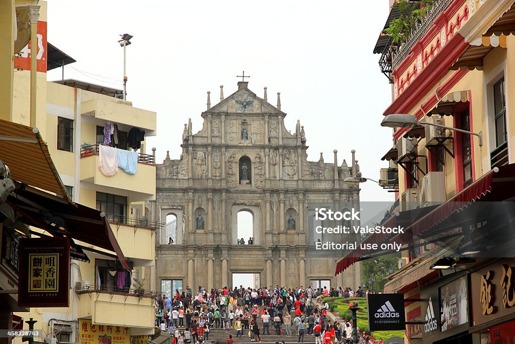 Ruins of St. Paul Macau, A!hina - April 2, 2012: People in a street in Downtown Macau and the Ruins of St. Paul in the background Abandoned Stock Photo