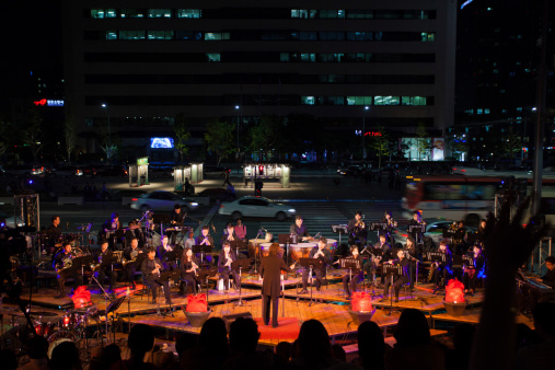 Seoul, South Korea - September 23, 2009: A full symphany orchestra plays music on a sidewalk near downtown traffic at a free summer night concert series on September 23, 2009 in Seoul, South Korea