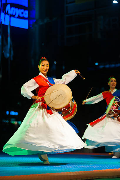 Seoul, Korea - September 17, 2009: An unidentified Korean women in hanbok spins and plays traditional janggu drums at a free open-air summer show near city hall on September 17, 2009 in Seoul, Korea