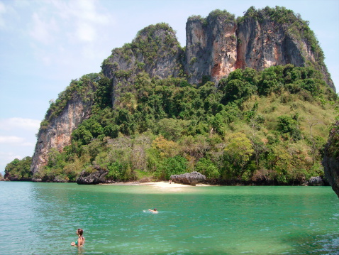 Ko Pakbia, Thailand - January 29, 2008: island hopping tour on the andaman sea. Western Tourists enjoy swimmming in the turquoise water, surrounded by giant limestone rocks of Rai island