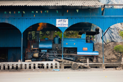 Darjeeling, India - December 27, 2007: An unidentified Indian driver stands in a parked toy train engine, a tourist attraction, in its shed on December 27, 2007 in Darjeeling, India