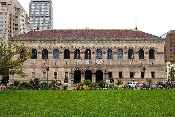 Boston MA, USA - The Boston Public Library, McKim Building as viewed from Copley Square Boston MA, USA - September 06, 2012: The Boston Public Library established in 1848, sits across Copley Square in the Back Bay area of Boston, Massachusetts; photo shows the lawns of the Square in the foreground. Cars and people move on the street between the Square and the Library. prudential tower stock pictures, royalty-free photos & images