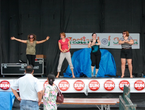 Ottawa, Canada - August 12, 2012: Women learning to dance, light-heartedly take to the stage at the inaugural Festival of India in Ottawa, Ontario.