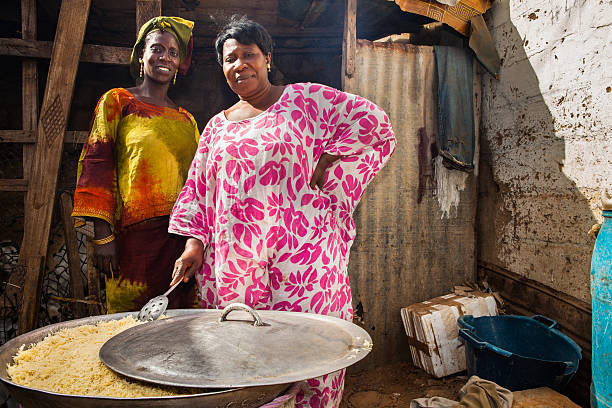 Dakar, Senegal - March 4, 2012: Two women are cooking pasta for a party in a traditional senegalese kitchen.\t