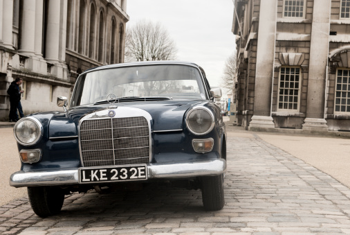 London, UK - February 16th, 2013:  A Classic Mercedes Benz is parked on a cobbled road side. The surrounding area is classical style 18th century stone buildings