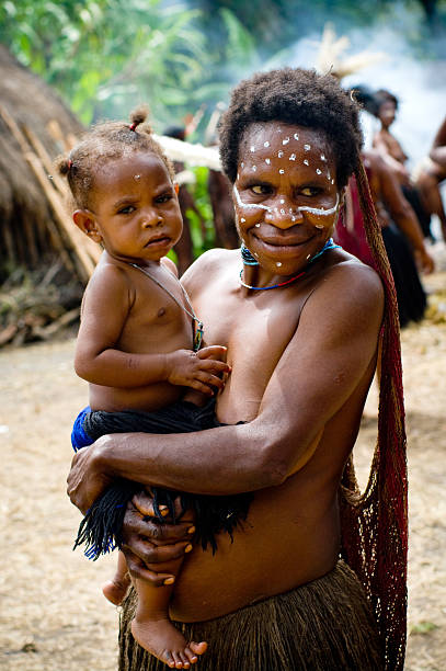 неидентифицированные женщина с ребенком в papuan tribe - dani стоковые фото и изображения