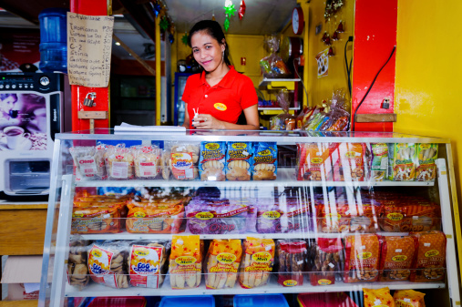 Cebu, Philippines - January 7, 2013: Portrait of market vendor at outdoor street stall selling baked goods in Cebu City, Philippines, Asia.