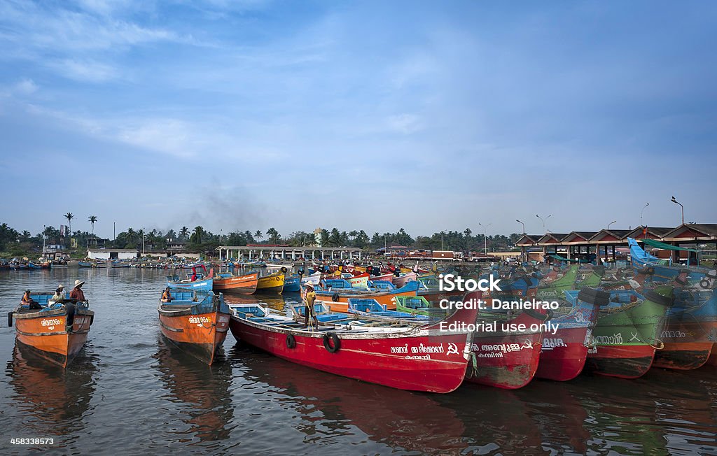 Fishing boats, Mapilla Bay harbour, Kannur, Kerala, India. Kannur, India - December 22, 2011: fishermen return from a day's fishing and moor their boats at Mapilla Bay harbour in Kannur, Kerala, India. The shot shows many traditional boats moored at the harbour. The sun has set and dusk is falling. The shot was taken in winter. Malabar Coast Stock Photo