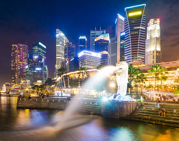 merlión y de los edificios de la ciudad de singapur al atardecer - merlion singapore marina bay lighting equipment fotografías e imágenes de stock