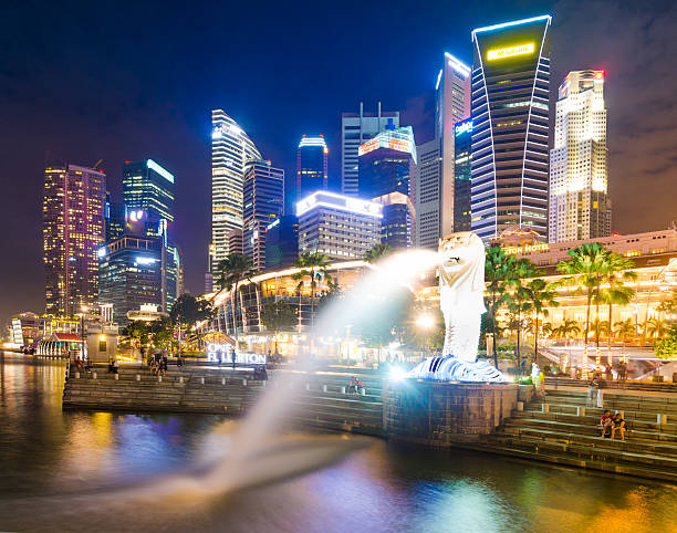 merlion de singapour et de la ville au crépuscule - marina bay sparse contemporary skyscraper photos et images de collection