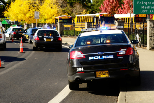 Roseburg Oregon - October 16, 2012: Police cars and school buses at an accident scene at the entrance of the High School loading zone