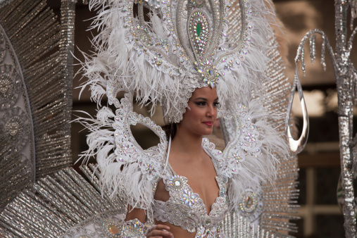 Las Palmas, Spain, February 16, 2013.  A beautiful woman in an elaborate costume rides on a parade float in the Grand Carnival Parade.  Carnival and the parade are held once every year on the Spanish Island of Gran Canaria in the Canary Islands.