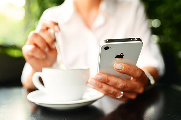 Woman using smartphone on wooden table in cafe. Close-up image with social networks concept