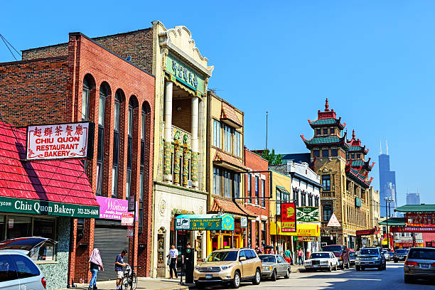 Chicago, USA - July 5, 2013: Wentworth Avenue in the center of Chinatown, Chicago.  Busy commercial street with many background people and cars. Located in the Amour Square community area of Chicago, on the South Side. Willis Tower in the background.