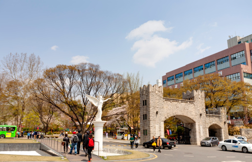 Seoul, Korea - April, 18th 2013. Kyung Hee University is a one of the most famous university in South Korea. It is comprehensive and private. Students are walking along the campus street.