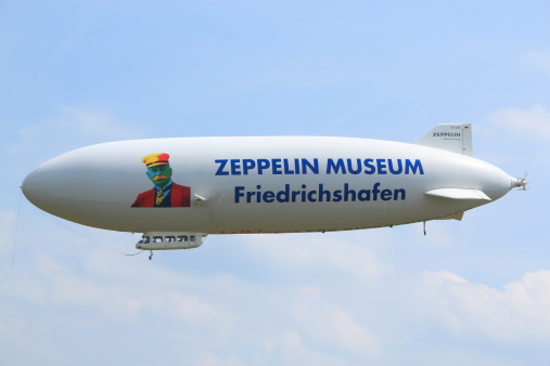 Friedrichshafen, Germany - July 9, 2013: Airship in Friedrichshafen. The Zeppelin hovers in the air. He starts to sightseeing flight over Lake Constance and the Alps. The passengers enjoy the fantastic view.   Friedrichshafen celebrates the 175th Birthday of Count Ferdinand von Zeppelin.