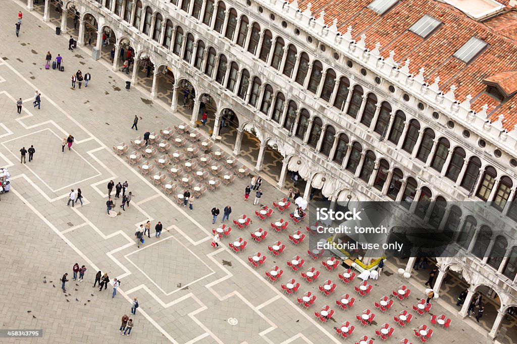 Cafe on the Piazza San Marco Venice, Italy - May 13, 2012: Aerial view to cafe on the Piazza San Marco, Venice, Italy. The few tourists walking in St. Mark's Square.  Aerial View Stock Photo