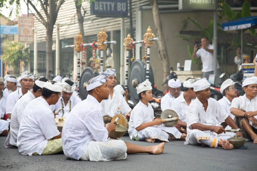 Bali, Indonesia - October 29, 2011: musicians from traditional balinese Orchestra Gamelan sitting on the street and plaing music during traditional ceremony in one of the street Seminyak area in Bali