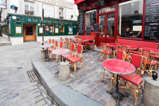 Paris, France - March 5, 2013: people in parisian restaurant on montmartre on Place Jean-Baptiste-Clement in Paris. Monsieur Clement was Mayor of Montmartre during 70 days of the 1871 Commune, when this area seceded from Paris