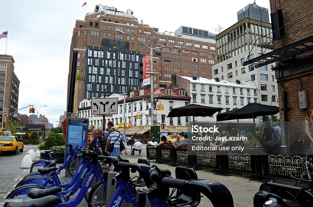 People at Citi Bike station, Meatpacking District, New York City New York City, USA - July 28, 2013: People at a Citi Bike sharing station and a outdoor cafe at 9th Ave. & W.14th Street, Meatpacking District in Lower Manhattan. Bicycle Sharing System Stock Photo