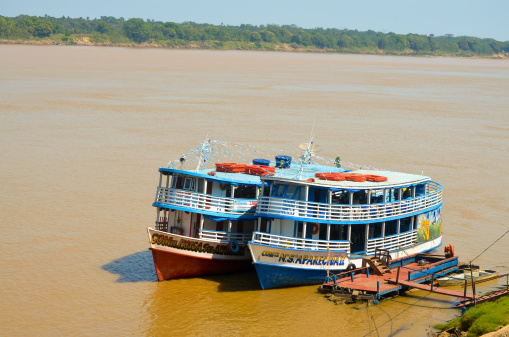 Porto Velho, Brazil - August 31, 2013: Two boats at Madeira River - Amazonia region.Porto Velho is the capital of the aRondA'niaaA state.  The city is located on the north of Brazil, at the course of Rio Madeira course.  ItA's a very old city, founded on 1914 and became the capital of its state on 1943. ItA's a medium size city with around 442,000 people living on there.The Madeira River is 17th largest river in the world in extension. Is located at the north of Brazil and in one Amazon River affluent. ItA's a very important river for the regional economy because of its logistics importance and also because it is the main income source of hundreds of families.
